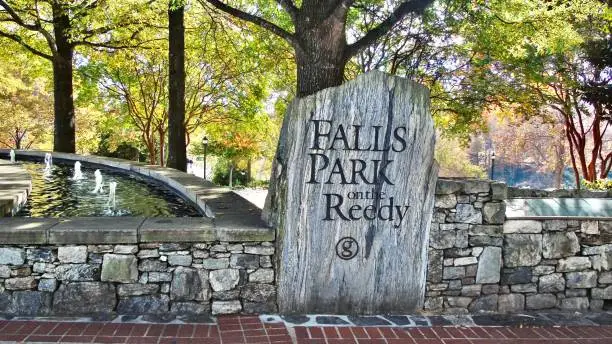 Photo of the flowing fountain waters compliment the stone placard denoting the falls park on the reedy in historic downtown greenville, south carolina.