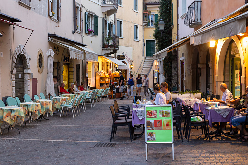 Torri del Benaco, Italy, July 11, 2016; People walk and eat in the historic center of the picturesque town of Torri del Benaco.