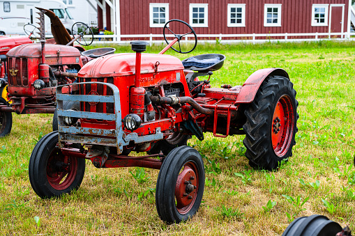 Lyngdal, Norway - June 27 2023: Vintage red Hanomag tractor in a field.