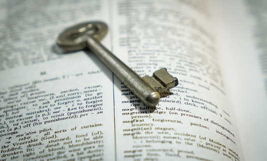 Old metal key on a book , illustration of knowledge is a power , by reading a book , key of success.
