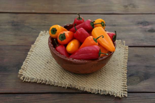 istock Bowl with ripe bell peppers on wooden table 1812011777