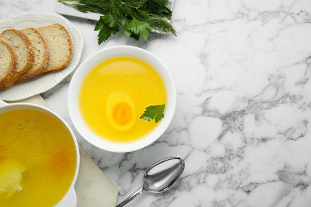 istock Delicious bouillon served on white marble table, flat lay. Space for text 1812011796