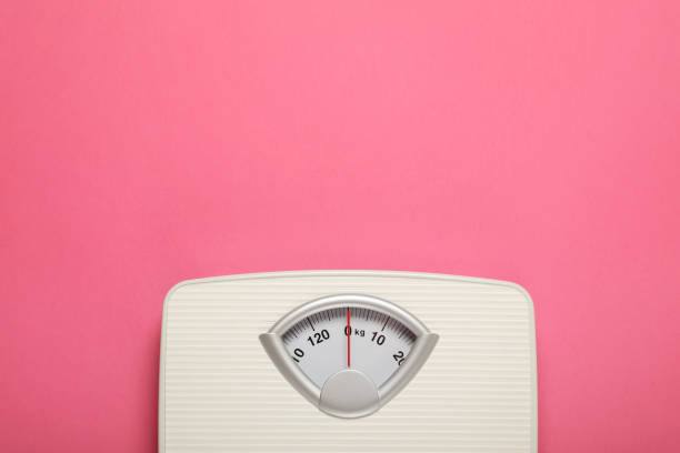 분홍색 배경에 저울의 무게, 텍스트를 위한 공간이 있는 평면도. 과체중 개념 - emaciated weight scale dieting overweight 뉴스 사진 이미지