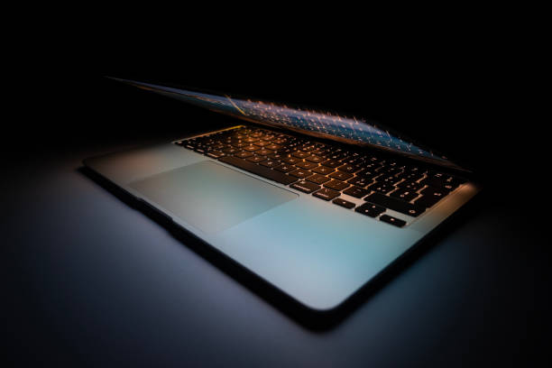 istock Half-open modern aluminium ultrabook with backlight keyboard on the table at night 1812043983