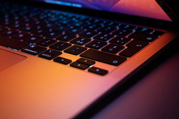 istock Keyboard of aluminum notebook, reflect screen highlight pink and orange color 1812043985