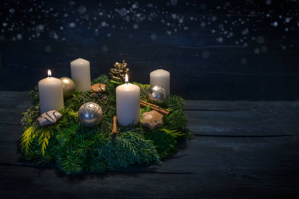 istock Green advent wreath with white candles, two are lit for second advent, Christmas decoration and cookies, dark blue wooden background with star bokeh, copy space 1812052960