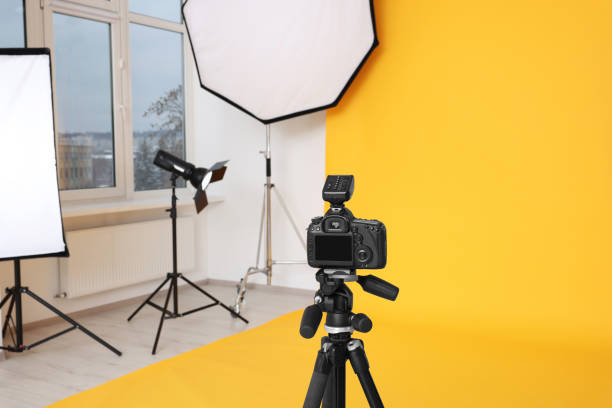 istock Camera on tripod and professional lighting equipment in modern photo studio 1812076177