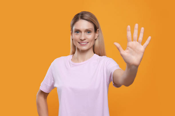 istock Woman giving high five on orange background 1812104911