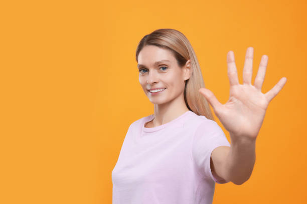 istock Woman giving high five on orange background, space for text 1812105421
