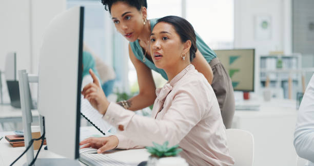 istock Business women, helping and computer for communication with documents, goals and kpi for teamwork planning. People, paper and training at investment agency with data, collaboration and work research 1812116418
