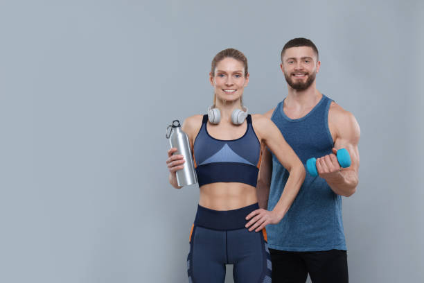 istock Athletic people with dumbbell, headphones and thermo bottle on grey background, space for text 1812120734