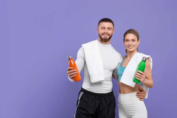 istock Athletic people with thermo bottles and towels on purple background, space for text 1812120895