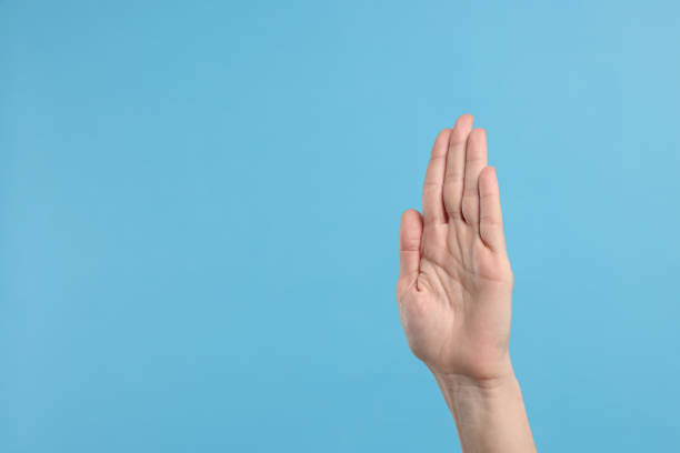 Woman giving high five on light blue background, closeup. Space for text