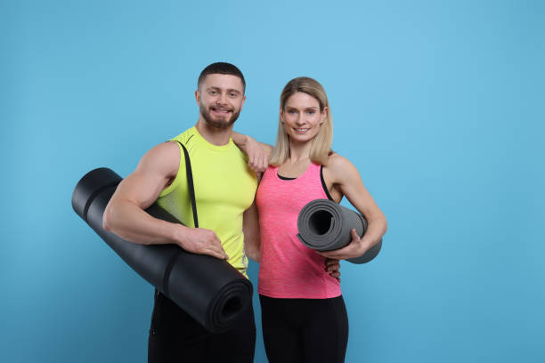 istock Athletic people with fitness mats on light blue background, space for text 1812121773