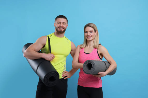 istock Athletic people with fitness mats on light blue background 1812121774