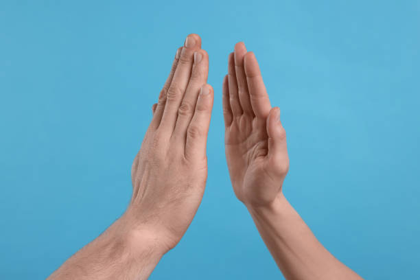 istock People giving high five on light blue background, closeup 1812139381