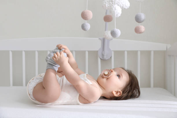 istock Cute little baby looking at hanging mobile in crib 1812145815