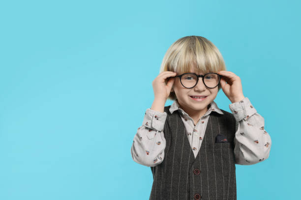 istock Cute little boy wearing glasses on light blue background, space for text 1812167759