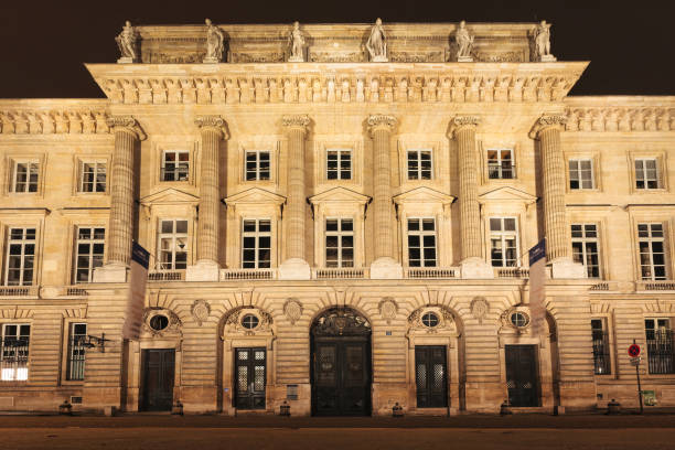 The illuminated facade of the Monnaie de Paris (Paris Mint) in Paris, France at night. It is the world's oldest continuously running minting institution.
