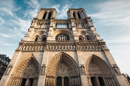 The facade of Notre Dame Cathedral in Paris, France on a sunny day.