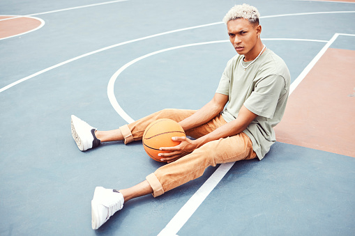 Black man, basketball court and portrait for fashion, sports or outdoor fitness in summer sunshine. Urban man, basketball player or sport for wellness, exercise or workout with edgy clothes in city