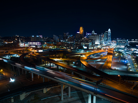 Aerial still image of Interstate 71 passing through Cincinnati, Ohio, with the downtown district visible in the distance at night. Authorization was obtained from the FAA for this operation in restricted airspace.