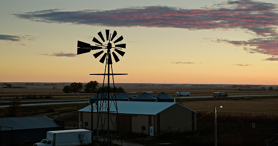 Aerial still image of a small windmill in the village of Brule, Nebraska at sunset.