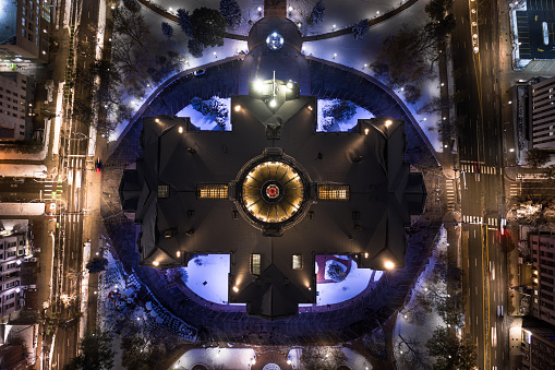 Aerial still image of the Colorado State Capitol building, taken by a drone flying directly above it on a snowy night in Denver.