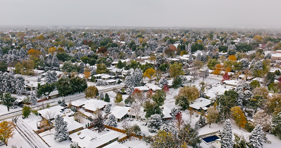 Aerial still image of the snowcapped houses in Denver, taken by a drone on a snowy, Fall day in Colorado.