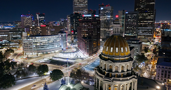 Aerial still image of the Colorado State Capitol building, taken by a drone on a snowy night in Denver.