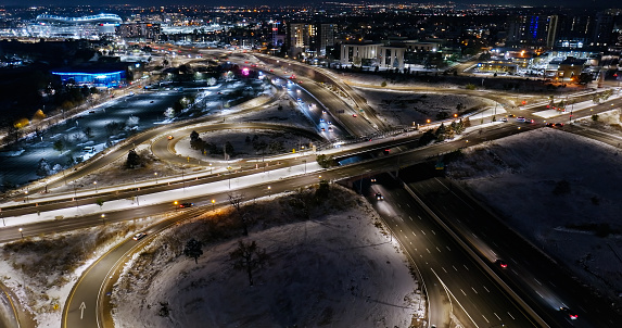 Aerial shot of Speer Boulevard crossing Interstate 25 on a snowy night in Denver, Colorado.