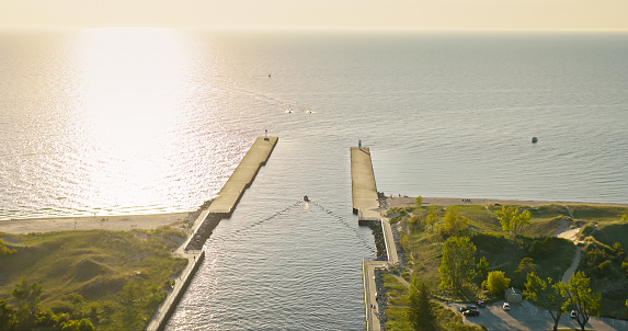 Aerial still image of an inlet between White Lake and Lake Michigan in Whitehall, Michigan, on a clear day in Fall.