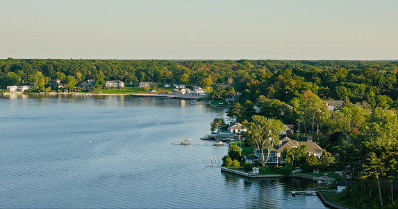 Aerial still of houses on White Lake in Whitehall, Michigan, on a clear day in Fall.