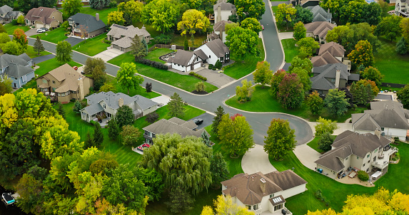 Aerial view of houses in Maple Grove, a suburban city in the Minneapolis-St. Paul metro area, Hennepin County, Minnesota, on an overcast day in Fall.