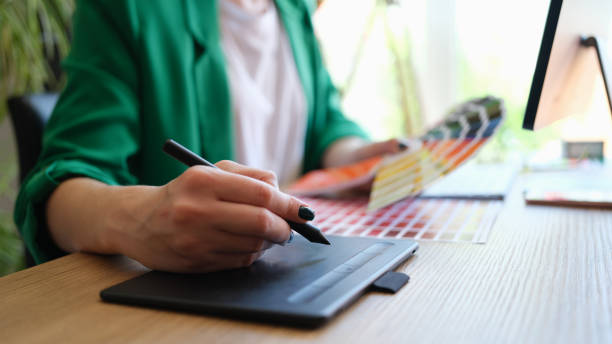 istock Designer draws sketches on graphics tablet and holds color palette 1812339215
