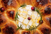 Breadbuns Christmas tree with camembert cheese, cranberries and rosemary on parchment paper. Christmas menu.