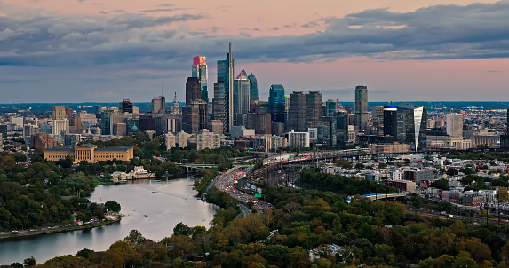 Aerial still image of the Center City skyline from over East Parkside in Philadelphia, Pennsylvania on a cloudy sunset in Fall.