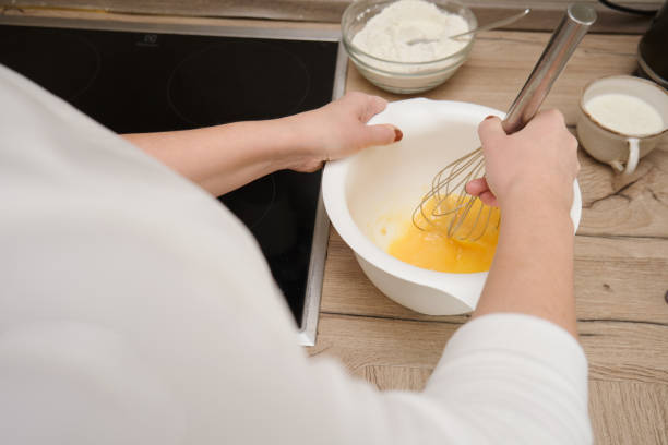 istock Close-up of a woman's hands whisking eggs in a bowl 1812349026