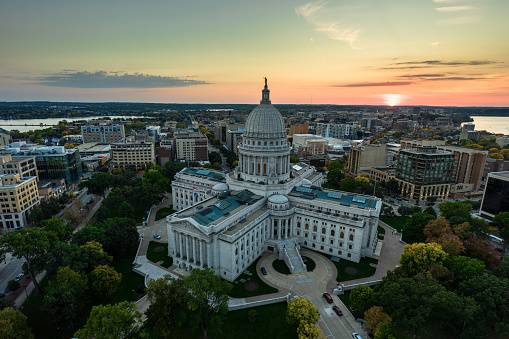 Aerial view of Wisconsin State Capitol building in downtown Madison, the capital city of Wisconsin, with Lake Mendota and Lake Monono on either sides of the frame at sunset in Fall.\n\nAuthorization was obtained from the FAA for this operation in restricted airspace.