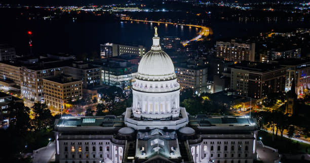 Aerial Shot of Madison's Wisconsin State Capitol with Lake Monona in Background at Night Aerial view of the Wisconsin State Capitol building in downtown Madison, the capital city of Wisconsin, at night in Fall.

Authorization was obtained from the FAA for this operation in restricted airspace. lake monona photos stock pictures, royalty-free photos & images