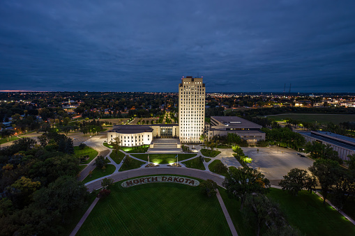 Aerial view of the North Dakota State Capitol building in Bismarck, the capital city of North Dakota, on an overcast sunset in Fall.\n\nAuthorization was obtained from the FAA for this operation in restricted airspace.