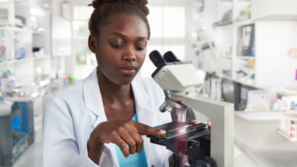 istock African female scientist, student or tech in a lab coat, works with a microscope 1812367771