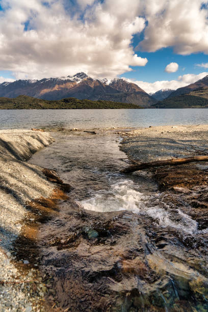 istock stream flowing into into a mountain lake 1812368284