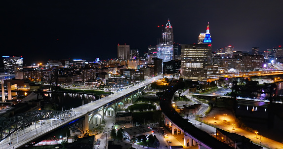 Drone shot of Cleveland at night, looking across the Cuyahoga River towards the downtown skyline from over Ohio City.
