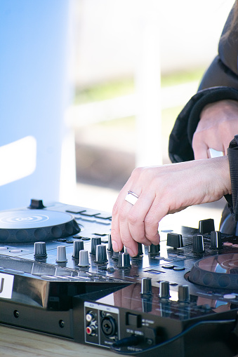 the intricate and skilled work of a DJ as they manipulate the controls on a mixing console.