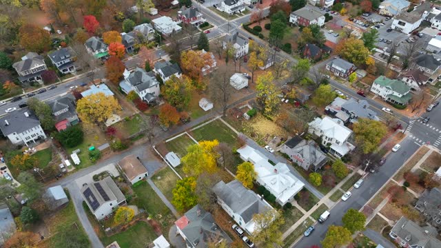 Residential neighborhood in small American town with colorful autumn trees and streets. Aerial tilt down shot.