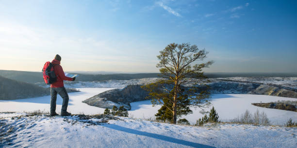 istock man hiking with map in mountains at winter season. panoramic banner with copy space. 1812485332