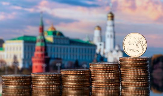 Coin with the symbol of the Russian ruble against the backdrop of the Moscow Kremlin