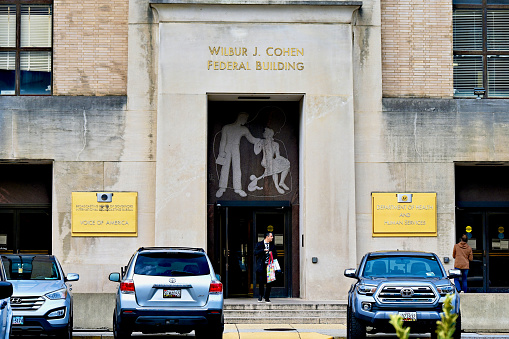 Washington, D.C., USA - November 20, 2023: A man departs the historic Wilbur J. Cohen Federal Building, home to the “Voice of America” and parts of the United States Department of Health and Human Services (HHS).