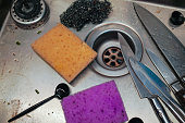 the knives and sponges in a kitchen sink need to be washed, indoor closeup